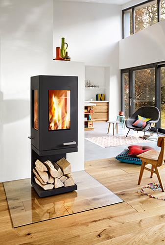 stufa a legna pico trifacciale della casa tedesca Skantherm wagner GmbH. stufa in acciaio grigio con maniglia design in acciaio inox. Stufa su di un piedistallo semplice, ma dall'eleganza innovativa e originale. Design essenziale