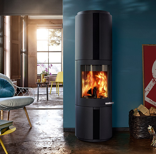 stufe a legna circolare Skantherm. Modello di design esclusivo. Un vero mobile di lusso. Stufa caminetto in acciaio nero con maniglia design cromata e ampio vetro arrotondato. Bellissima fiamma.